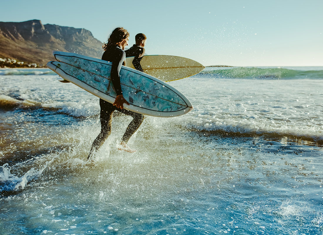Man and woman with Surfboards going Surfing in the Blue Ocean on the Sunny, Beautiful Island of Hawaii